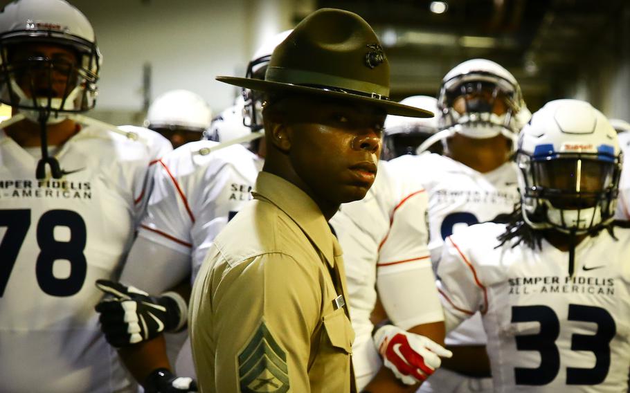 U.S. Marine Corps Staff Sgt. John L. Walker, a drill instructor from Marine Corps Recruit Depot San Diego, leads out the Team West players before the Semper Fidelis All-American Bowl Jan. 4, 2015, at The StubHub Center in Carson, Calif.