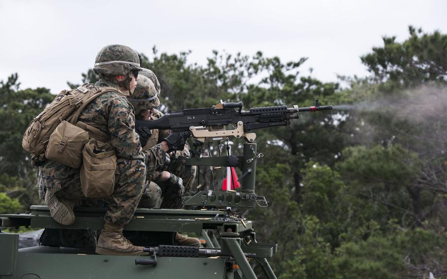 Lance Cpl. Felix C. Jovel, right, fires an M240B medium machine gun from a 7-ton truck as Cpl. Anthony Durham, left, observes during training Jan. 7, 2015, at Range 9 in the Central Training Area on Okinawa.