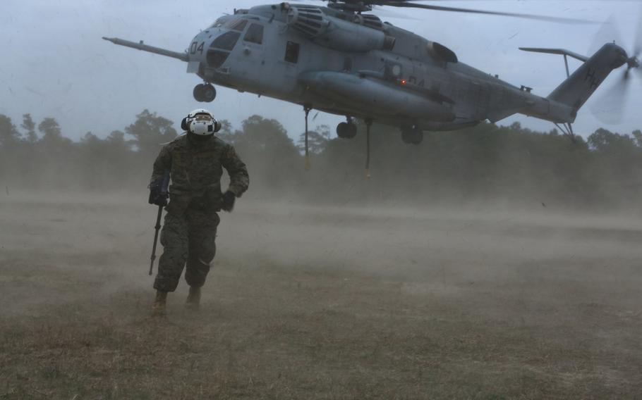 Cpl. Gregory D. Boyd, a combat videographer assigned to Marine Wing Headquarters Squadron 2, moves to a safe distance from a CH-53E Super Stallion during an external lift training exercise on Camp Lejeune, N.C., Jan. 7, 2015.