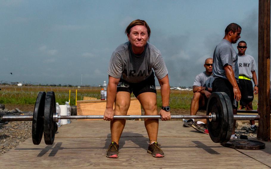 Capt. Melanie Bowman, Forward Surgery Team commander, 61st medical detachment, 86th Combat support hospital, performs a dead-lift during a functional fitness competition, in honor of the holidays and Army spirit, held at Roberts International Airport, Monrovia, Liberia, Dec. 24, 2014.