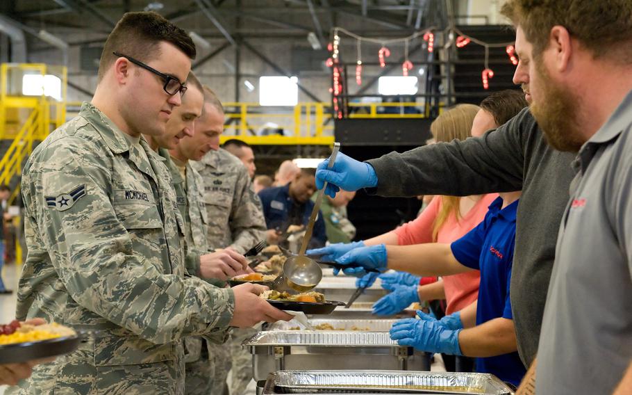 Airman 1st Class Jeffrey McMichael, 736th Aircraft Maintenance Squadron, goes through the serving line during the 10th Annual ''Feed the Troops'' day shift dinner Dec. 23, 2014, at Dover Air Force Base, Del.