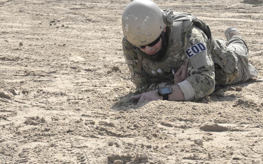 Staff Sgt. Ace, explosive ordnance disposal technician, works to unbury a simulated improvised explosive device during a training exercise at an undisclosed location in Southwest Asia on Tuesday, Dec. 30, 2014. EOD trains on IEDs and suicide bomber scenarios as well as suspicious packages and suspicious vehicles.