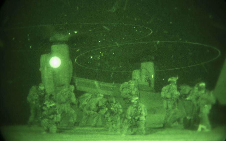 Marines provide security as others board an MV22B Osprey Jan. 10, 2015 at Camp Courtney in Okinawa, Japan. The Marines with the 31st Marine Expeditionary Unit?s Maritime Raid Force took part in a night raid as the first of three situational training events that make up the Realistic Urban Training Exercise.