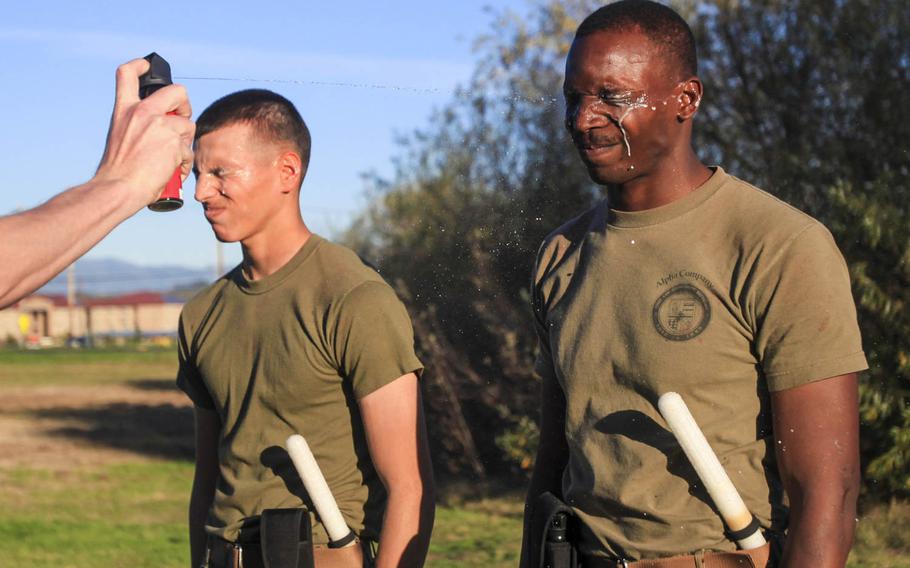 Two Marines with 1st Law Enforcement Battalion experience Oleoresin Capsicum spray at Camp Pendleton, Calif., Jan. 14, 2015. OC is a chemical agent compound mixed with different peppers that irritates the eyes, which causes tears, burning of the skin, involuntary muscle relaxation and temporary blindness to incapacitate an individual for a short period of time.