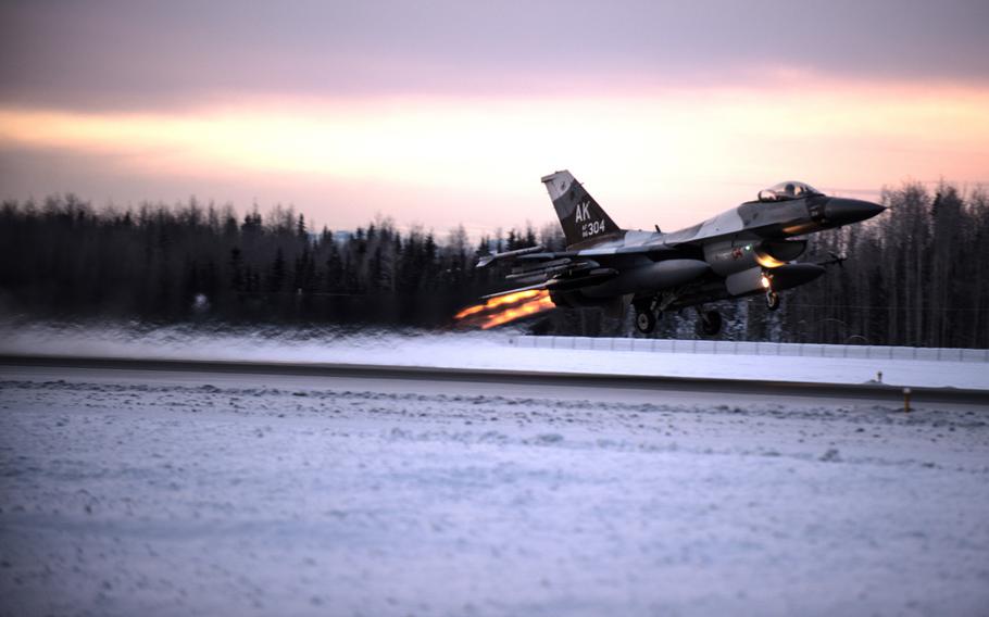 One of 14 U.S. Air Force F-16 Fighting Falcon aircraft with the 18th Aggressor Squadron takes off from Eielson Air Force Base, Alaska, shortly after sunrise on Saturday, Jan. 17, 2015.