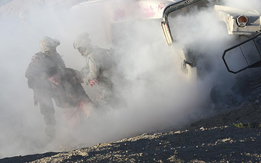 Marines with the 1st Marine Logistics Group, pull an injured Marine from a simulated burning vehicle during first responder training during Integrated Training Exercise 2-15 at Camp Wilson on Twentynine Palms, Calif., on Jan. 24, 2015.
