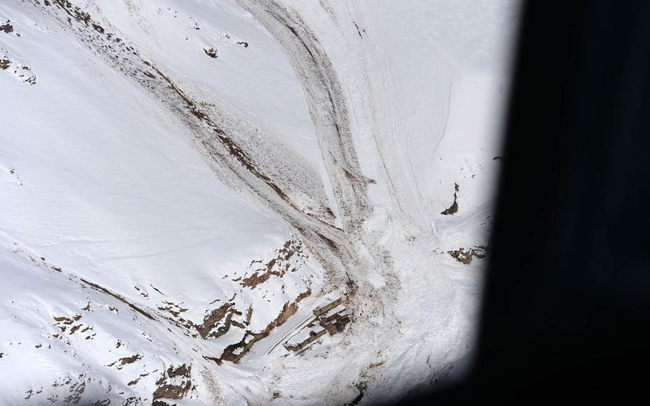 A village buried by an avalanche is seen from the open door of an Afghan Air Force Mi-17 helicopter over Panjshir valley on Saturday,  Feb. 28, 2015. Several days of heavy snow caused avalanches across the mountains of central and northern Afghanistan, causing as many as 200 deaths.
