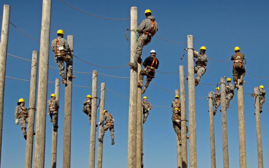 Students of the 364th Training Squadron's electrical systems course practice climbing power poles as part of a familiarization and trust exercise with the safety equipment on Feb. 3, 2015, at Sheppard Air Force Base, Texas.