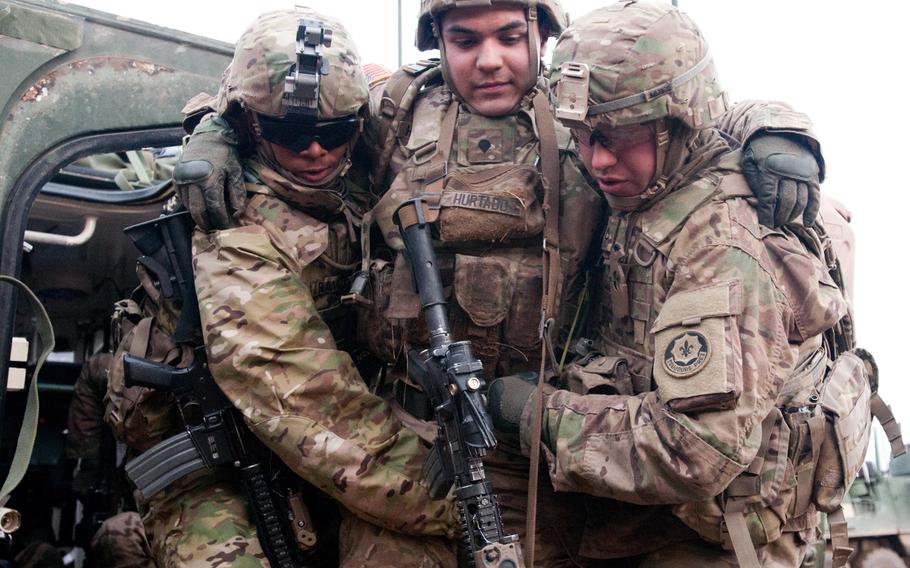 Pvt. D?Angelo Ravizee, left, and Pvt. 1st Class Shane Baer carry Spc. Tobbi Hurtado, a team leader with K Troop, 3rd Squadron, 2nd Cavalry Regiment, to safety during a raid exercise at Drawsko Pomorskie Land Forces Training Center, Poland, Feb. 28, 2015, in preparation for an upcoming live-fire exercise with the Polish army.