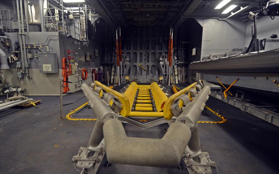 A rigid-hulled inflatable boat carried by the USS Fort Worth is lifted by a crane, loaded into this bay and then exits the craft through the doors ahead during missions, ship officials said during a tour in Busan, South Korea on Saturday.