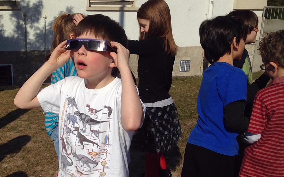 Tommy Morgenfeld, a second-grader at Boeblingen Elementary and Middle School in Stuttgart, Germany, watches a solar eclipse Friday, March 20, 2015, with protective glasses provided by his teacher, Karen Sipes.