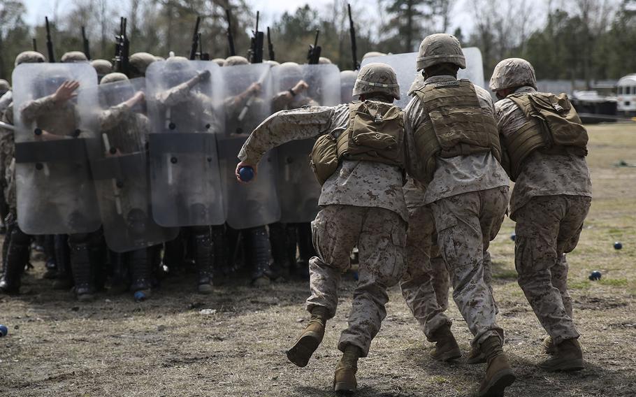 Marines with the 2nd Battalion, 6th Marines, acting as role-players, rush into a blockade of Marines as part of a riot-control exercise aboard Camp Lejeune, N.C., on March 24, 2015.