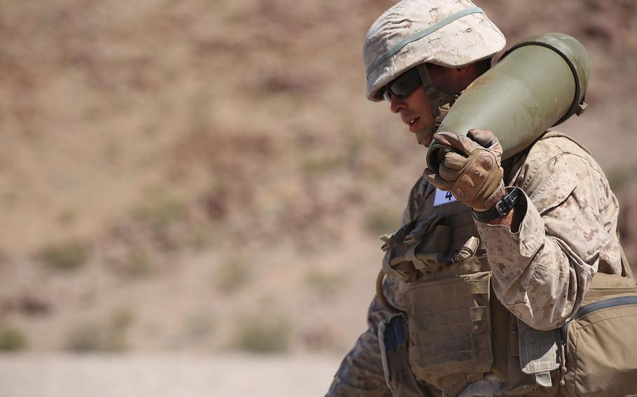 Cpl. Joshua J. Syverson, combat engineer, Engineer Platoon, Headquarters and Service Company, Ground Combat Element Integrated Task Force, carries a 155 mm shell during cache reduction as part of a Marine Corps Operational Test and Evaluation Activity assessment at Range 114, Marine Corps Air Ground Combat Center Twentynine Palms, California, on March 23, 2015.