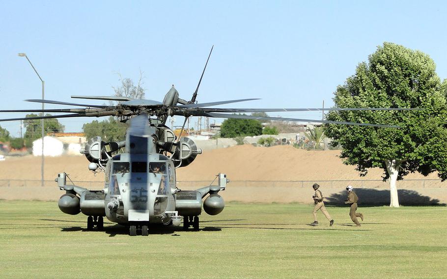 Marines run to re-board a CH-53E Super Stallion after it touched down in a park in Yuma, Ariz., Friday, as part of a training exercise. The Marines are completing a seven-week training course that will allow them to train their squadrons for a variety of missions.