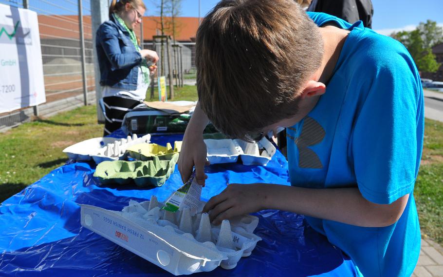 Bryce Wehmeyer sprinkles flower seeds in an egg carton on April 22, 2015, outside the U.S. Army Garrison Rheinland-Pfalz Main Library at Landstuhl, Germany. For Earth Day, the library provided patrons with a variety of flower and vegetable seeds that they could plant in an egg carton to take home and grow a garden.