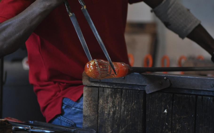Lwapgan Suranga works with a pair of tongs to create a vase at the Guarnieri glass factory on Murano island  in Venice, Italy.