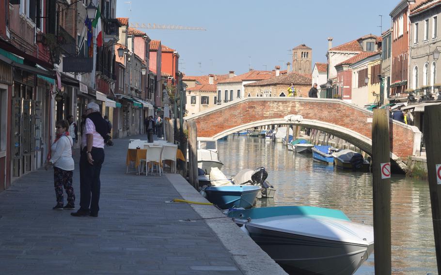 Sidewalks, lined with dozens of shops selling an array of items crafted of Venetian glass, are situated on either side of a canal that serves as the main thoroughfare on Murano in Venice, Italy.
