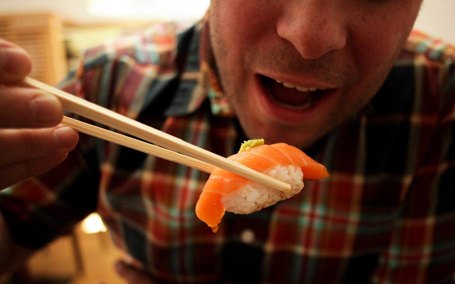 Stars and Stripes photographer Joshua L. DeMotts gets ready to devour a piece of salmon nigiri sushi at Ayame, a Japanese restaurant in Kaiserslautern.