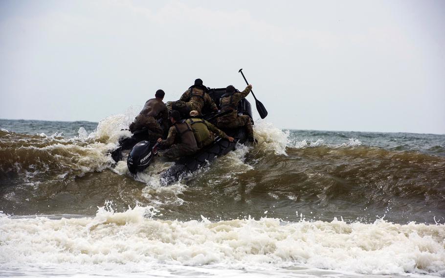 Members of the Army National Guard's 20th Special Forces Group (Airborne) enter the water at Naval Station Mayport, Fla., on April 29, 2015.