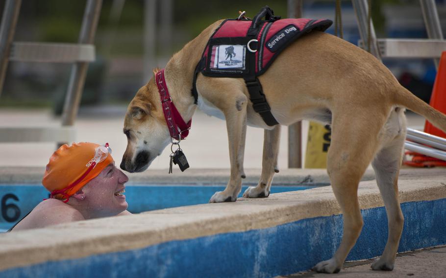 Melissa Gonzales, an Air Force Wounded Warrior athlete, shares a moment with her service dog, Bindi, after swimming laps during the fourth day of an introductory adaptive sports and rehabilitation camp at Eglin Air Force Base, Fla., on April 16, 2015.