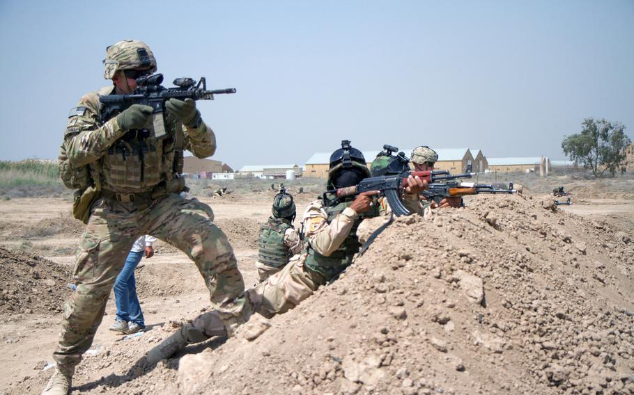 Iraqi army soldiers with the 73rd Brigade, 15th Division, provide cover fire for their platoonmates while a U.S. soldier, left, with 5th Squadron, 73rd Cavalry Regiment, 3rd Brigade Combat Team, 82nd Airborne Division, demonstrates how to aim properly during a cumulative training event at Camp Taji, Iraq, April 16, 2015.