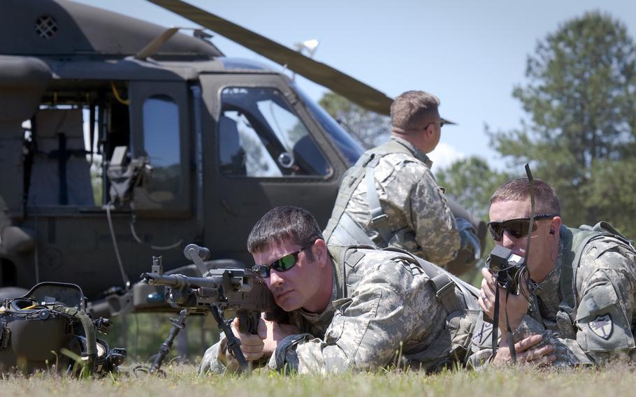Sgt. Brandon Painter of the South Carolina Army National Guard, uses a M240 to assist with establishing a perimeter defense around a U.S. Army UH-60 Black Hawk helicopter while Warrant Officer Joshua O?Handley calls for a MEDEVAC as part of a personnel recovery and downed aircraft training exercise at the McCrady Training Center, Eastover, S.C., May 3, 2015.