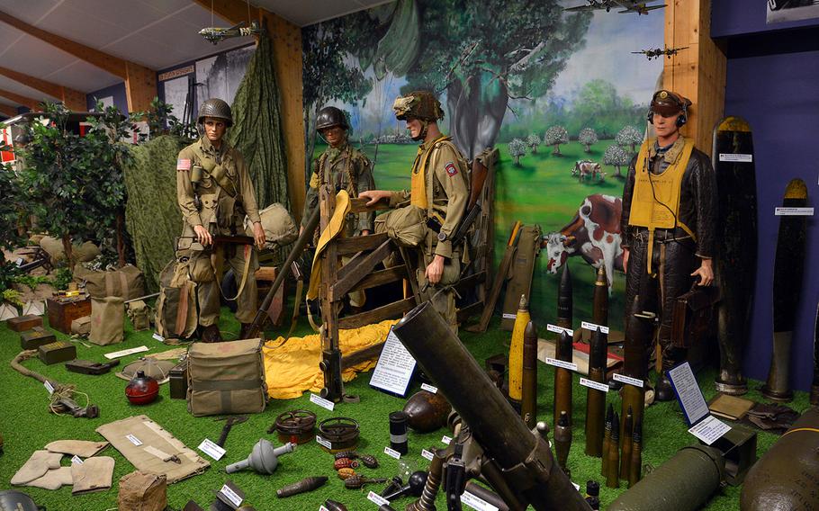 A display at the Omaha Beach Memorial Museum shows mannequins dressed as American paratroops and a pilot, and equipment and weapons used during the Normandy invasion. 