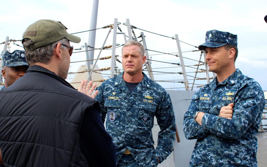 Eric Dane, center, who plays Cmdr. Tom Chandler on the TNT Drama "The Last Ship," and Cmdr. Chanden Langhofer, right, the real-life commanding officer of the USS William P. Lawrence, chat with Steven Kane, co-creator and executive producer of the show, during filming on the ship at Naval Base San Diego.