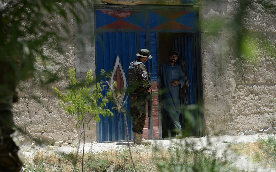 An Afghan Army officer questions a villager about a suspected rocket position in the area during a June 10, 2015, security patrol in Parwan province, central Afghanistan.