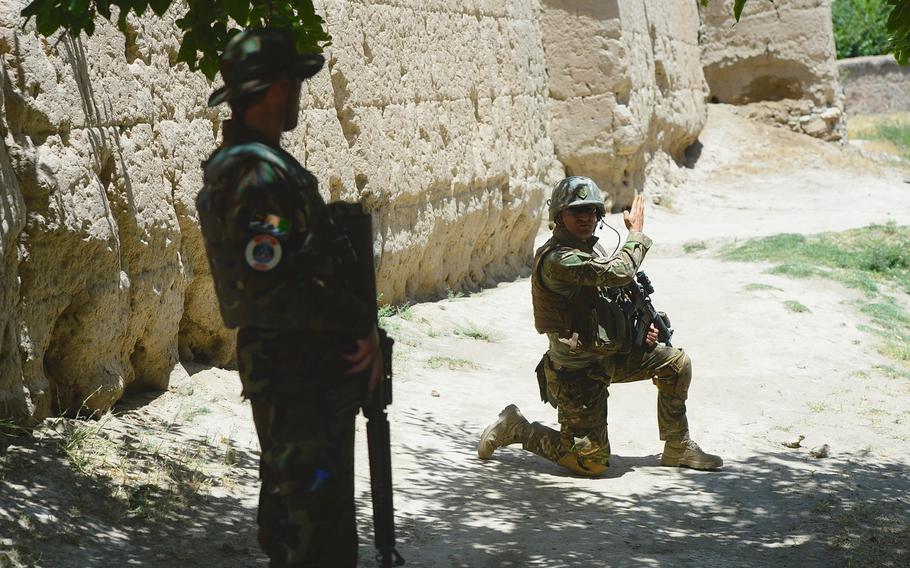 Master Sgt. Gogita Getia, 43rd Georgian Light Infantry Battalion, directs Afghan troops into position around a compound outside Bagram Air Field during a June 10, 2015, force protection mission in Parwan province, central Afghanistan.