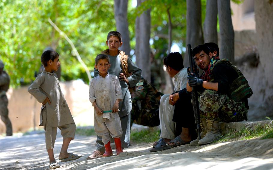 An Afghan soldier takes a break to joke with local children during a June 10, 2015, force protection patrol with U.S. and NATO forces in Parwan province, central Afghanistan.