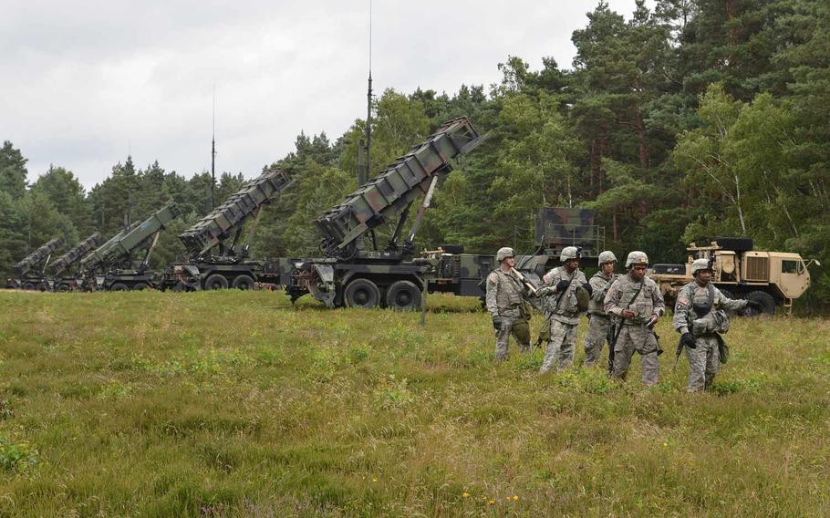 Patriot missile launchers of Battery D, 5th Battalion, 7th Air Defense Artillery, stand ready in a field near Minden, Germany, less than two hours after they crossed the Weser River over a temporary bridge during Minden Shock, a training exercise that included American, German and British soldiers, with observers from Belgium and Poland.