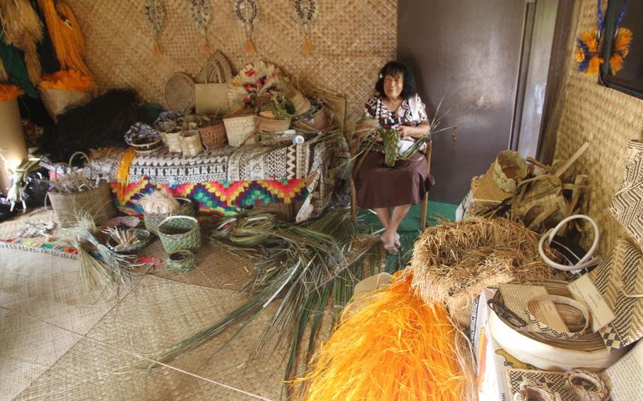A woman explains the traditional Fiji skill of weaving palm-frond baskets.