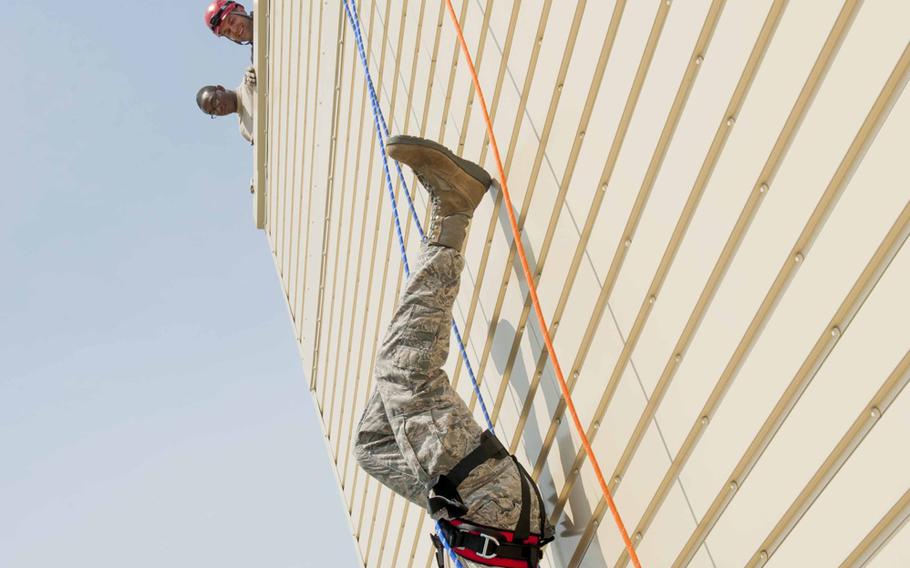 An airman from the 5th Civil Engineer Squadron hangs upside down during rappelling training at Minot Air Force Base, N.D., on Sunday, July 9, 2015. Repelling was a portion of a rope-rescue class provided to airmen to prepare them to descend down the side of buildings or enter confined spaces.