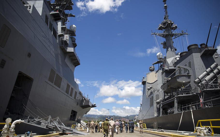 Approximately 25 U.S. personnel, as well as Japanese and Australian liaison officers, walk between the JS Hyuga, left, and JS Ashigara during a tour of Japan Maritime Self-Defense Force ships, Aug. 4, 2015, on Joint Base Pearl Harbor-Hickam, Hawaii.