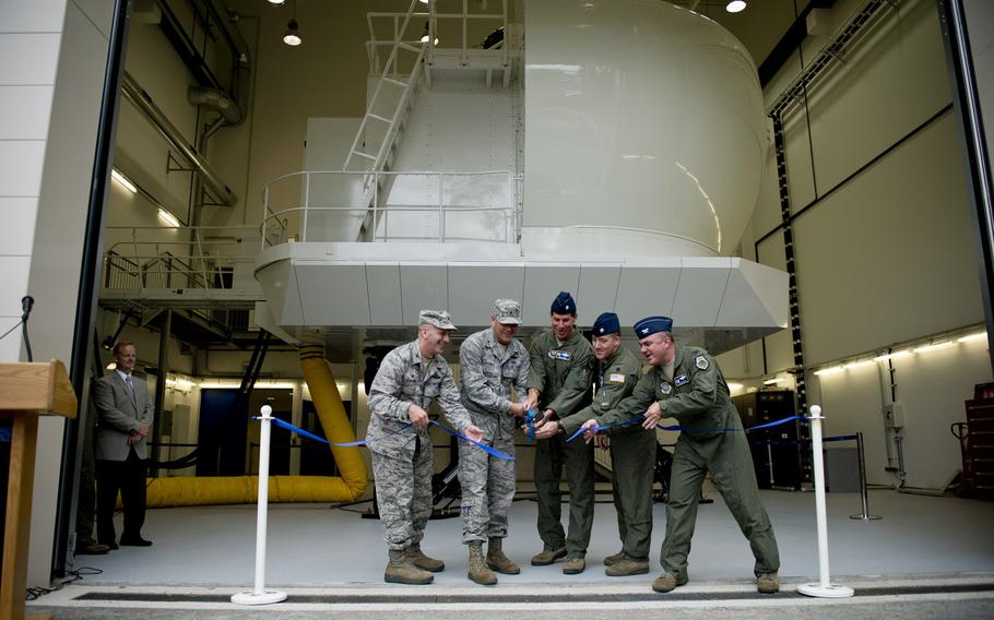 Brig. Gen. Jon T. Thomas, 86th Airlift Wing commander, second from left, and other 86th Airlift wing leaders cut a ribbon during the C-130J simulator opening ceremony at Ramstein Air Base, Germany, Monday, Aug. 24, 2015. Ramstein is the first U.S. Air Force base overseas to employ a C-130J simulator for its pilots and aircrews.