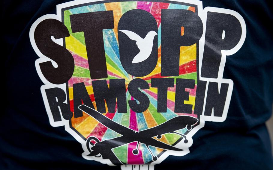 A protestor wears a shirt with the Stopp Ramstein - no Drone War logo during a demonstration outside Ramstein Air Base, Germany, on Saturday, Sept. 26, 2015.