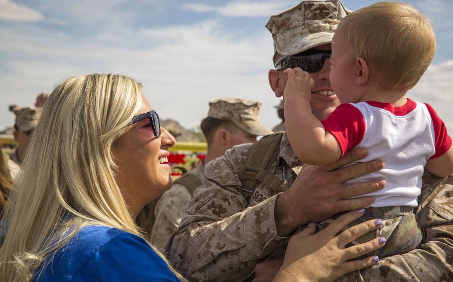 Sgt. Joshua Sorensen, motor transport operator, 3rd Battalion, 7th Marine Regiment, and his wife Susan, embrace their son, Gunner, 9 months, during the battalion's homecoming at Del Valle Field, Oct. 19, 2015.
