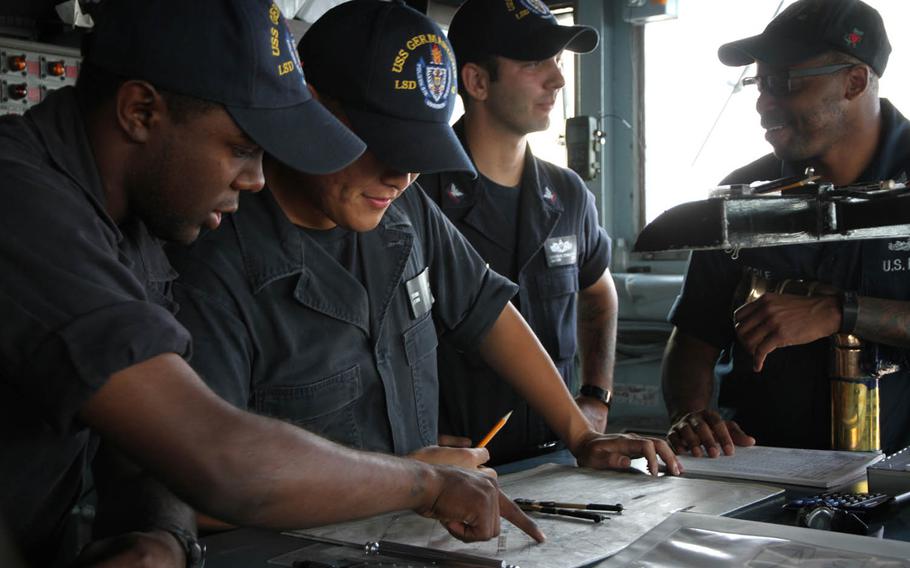 Sailors on the bridge of the USS Germantown, an amphibious dock landing ship, plot their course last week during exercise Blue Chromite 16 near Okinawa, Japan.