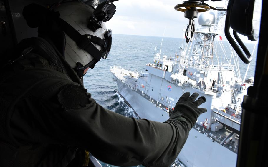 Naval Air Crewmen 2nd Class Bob Ross, assigned to Helicopter Squadron 14, waves to sailors aboard the South Korean mine laying ship ROKS Wonsan, from the starboard side of an MH-53E Sea Dragon helicopter following its landing during exercise Clear Horizon Nov. 11, 2015.