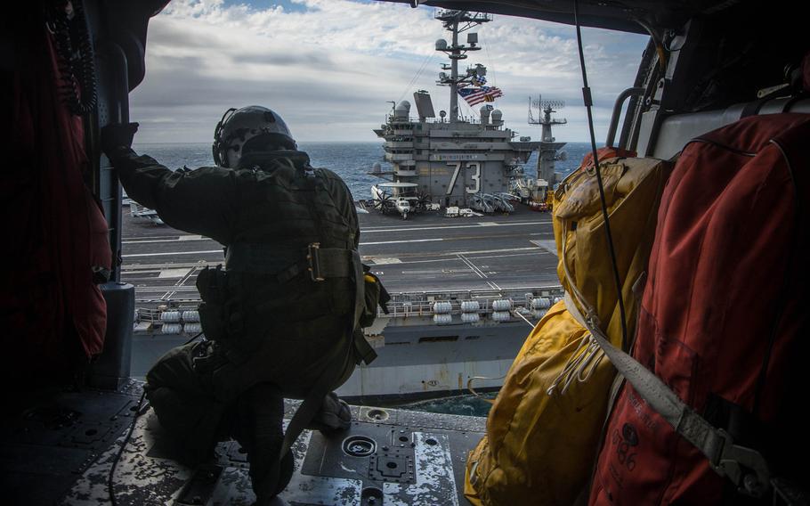 An MH-60S  Sea Hawk helicopter to the "Black Knights" of Helicopter Sea Combat Squadron 4  prepares to land on the flight deck of the aircraft carrier USS George Washington on Nov. 17, 2015.