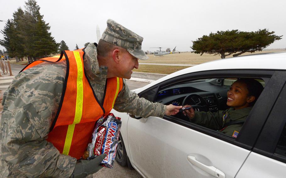Chief Master Sgt. Samuel Couch, 90th Missile Wing command chief, hands 1st Lt. Caryn Morales, 320th Missile Squadron, a piece of candy as she exits F.E. Warren Air Force Base, Wyo., Nov. 25, 2015. Couch joined other members of the 90th MW leadership in wishing Airmen a happy Thanksgiving.
