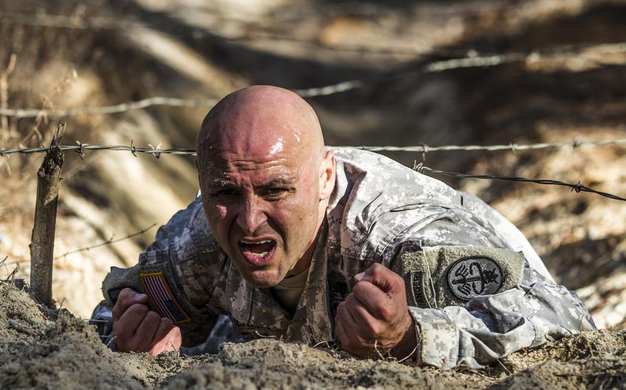 1st Sgt. Ricardo Gutierrez  low crawls under the wire obstacle on the confidence course during the assessment phase of the Best Ranger competition held at Fort Jackson, S.C., Nov. 24, 2015.