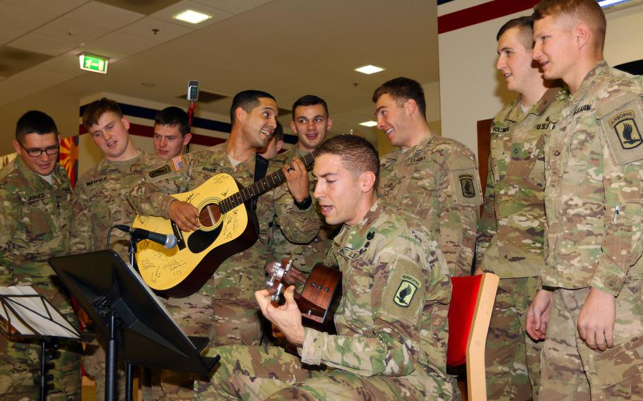 Soldiers from Able Company, 2nd Battalion, 503rd Infantry Regiment, 173rd Airborne Brigade, sing ''The Eighth of November,'' by artist Big & Rich, during a Thanksgiving meal at the Caserma Del Din dining facility, Nov. 24, 2015. The guitar used during the performance was signed by Big & Rich and donated by George Massey, a former Able Company soldier who served during Vietnam.