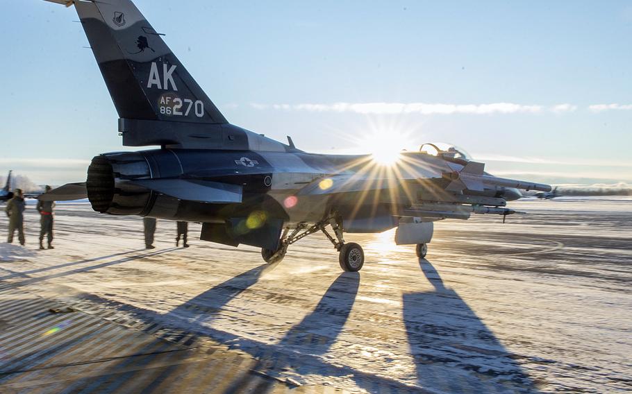 A U.S. Air Force F-16 Fighting Falcon fighter aircraft, assigned to the 18th Aggressor Squadron at Eielson Air Force Base, Alaska, leaves a hangar into minus 9-degree temperatures Dec. 1, 2015, for a sortie in the Joint Pacific Alaska Training Range Complex.