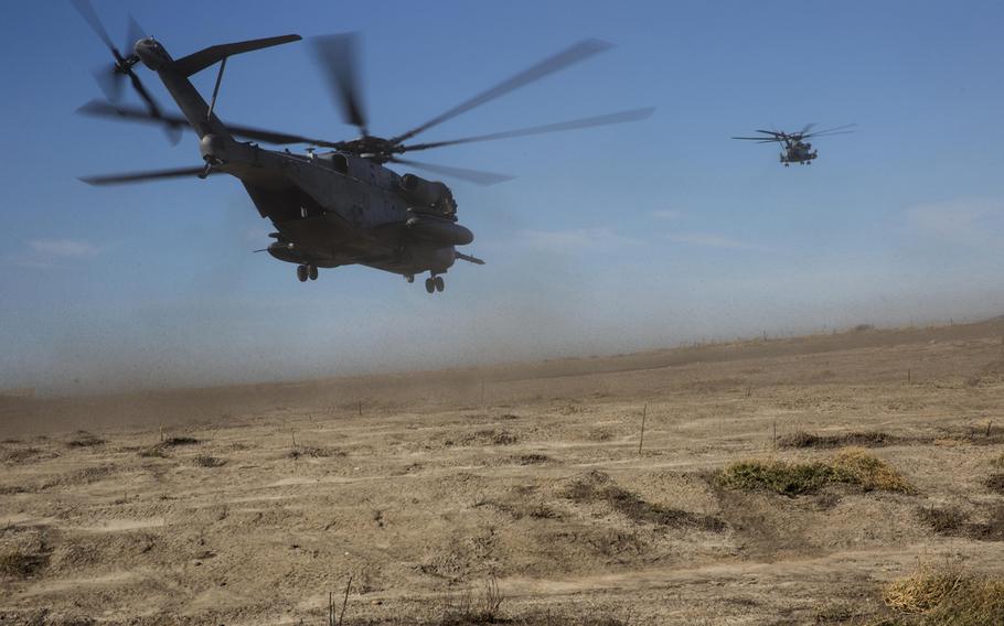 Two CH-53E Super Stallions take off during section Confined Area Landings board Marine Corps Base Camp Pendleton, Calif., Dec. 2, 2015.