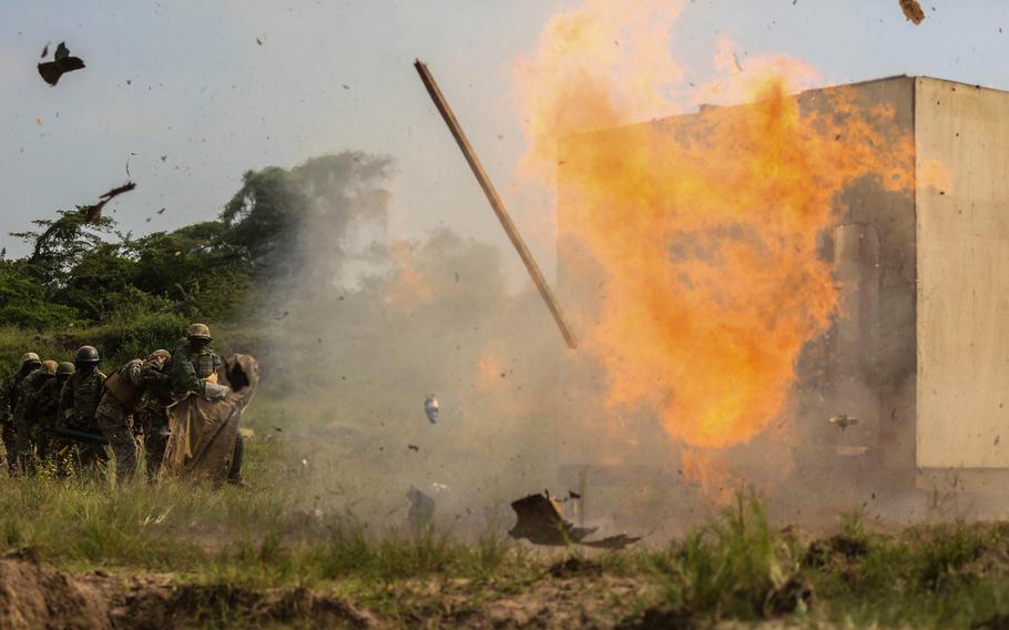 A Uganda People?s Defense Force soldier detonates an "oval charge" on desired entry point during a breaching exercise at Camp Singo, Uganda,  Dec. 8, 2015.