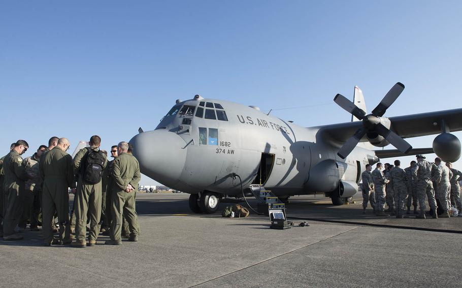 Members of the 374th Airlift Wing from Yokota Air Base, Japan, review safety procedures on Dec. 7, 2015, before leaving for Andersen Air Force Base, Guam, in support of Operation Christmas Drop 2015. An airman from the 374th Airlift Wing was found unresponsive during post-flight inspections after a training mission at Andersen and died Sunday, Dec. 13, 2015. The cause of death is under investigation.