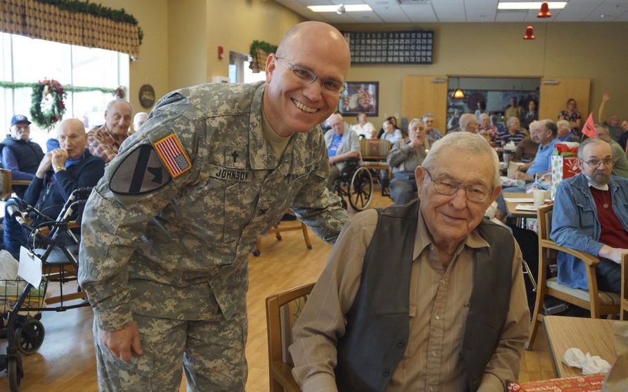 Col. David L. Johnson, North Dakota National Guard Chaplain, visits with veteran Stanley Wald during an outreach event Dec. 21, 2015, at the North Dakota Veterans Home in Lisbon, N.D. Soldiers and Airmen of the North Dakota National Guard visited the home, delivered gifts and shared a holiday meal with the veterans.