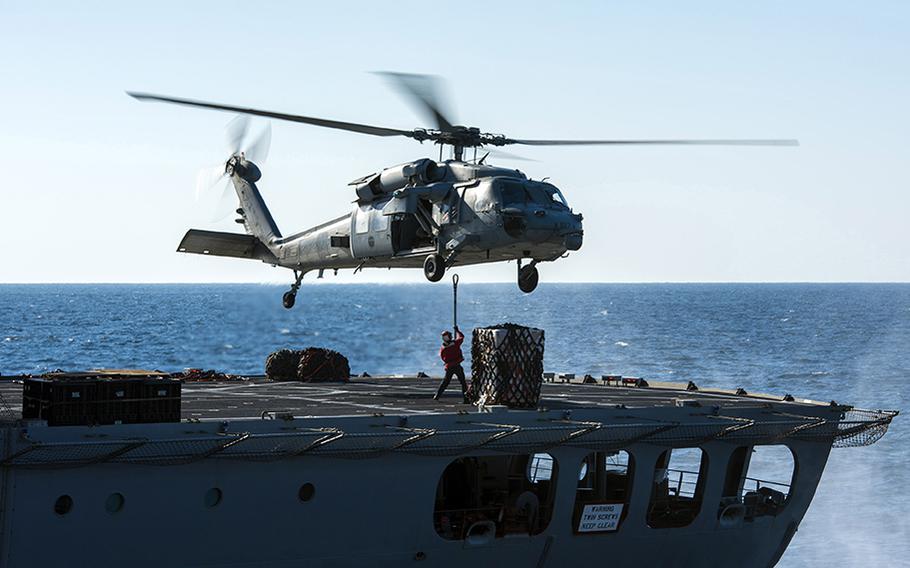 An MH-60S Sea Hawk helicopter, assigned to the ''Nightdippers'' of Helicopter Sea Combat Squadron 5, prepares to transfer supplies from fleet replenishment oiler USNS John Lenthall to aircraft carrier USS Harry S. Truman during a vertical replenishment Dec. 24, 2015.